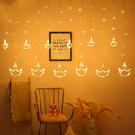 Close-up of warm white Diya Curtain String Lights illuminating a festive window.