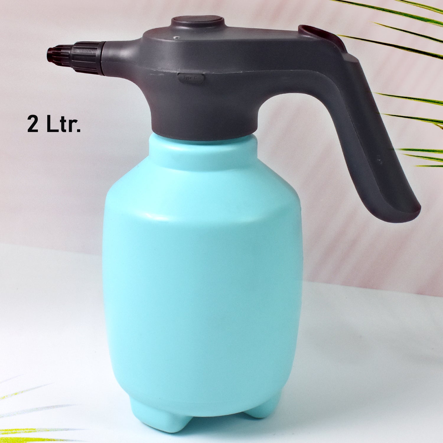 Electric garden sprayer in use, watering a plant with a fine mist.