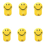 Close-up of a plastic smiley face hook demonstrating its self-adhesive backing.