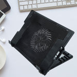 Sleek black laptop cooling pad with fan and adjustable stand, ready for use.