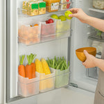 Top-down view of a clear plastic drawer organizer with several small items inside.