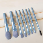 A person holding a blending brush from the 8-piece mini makeup brush set, demonstrating its size.