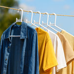 White plastic clothes hanger in practical use inside a closet