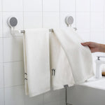 Towel rack bar installed on bathroom wall using adhesive mount