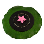 Solar garden fountain pump floating on water with green base and solar panel