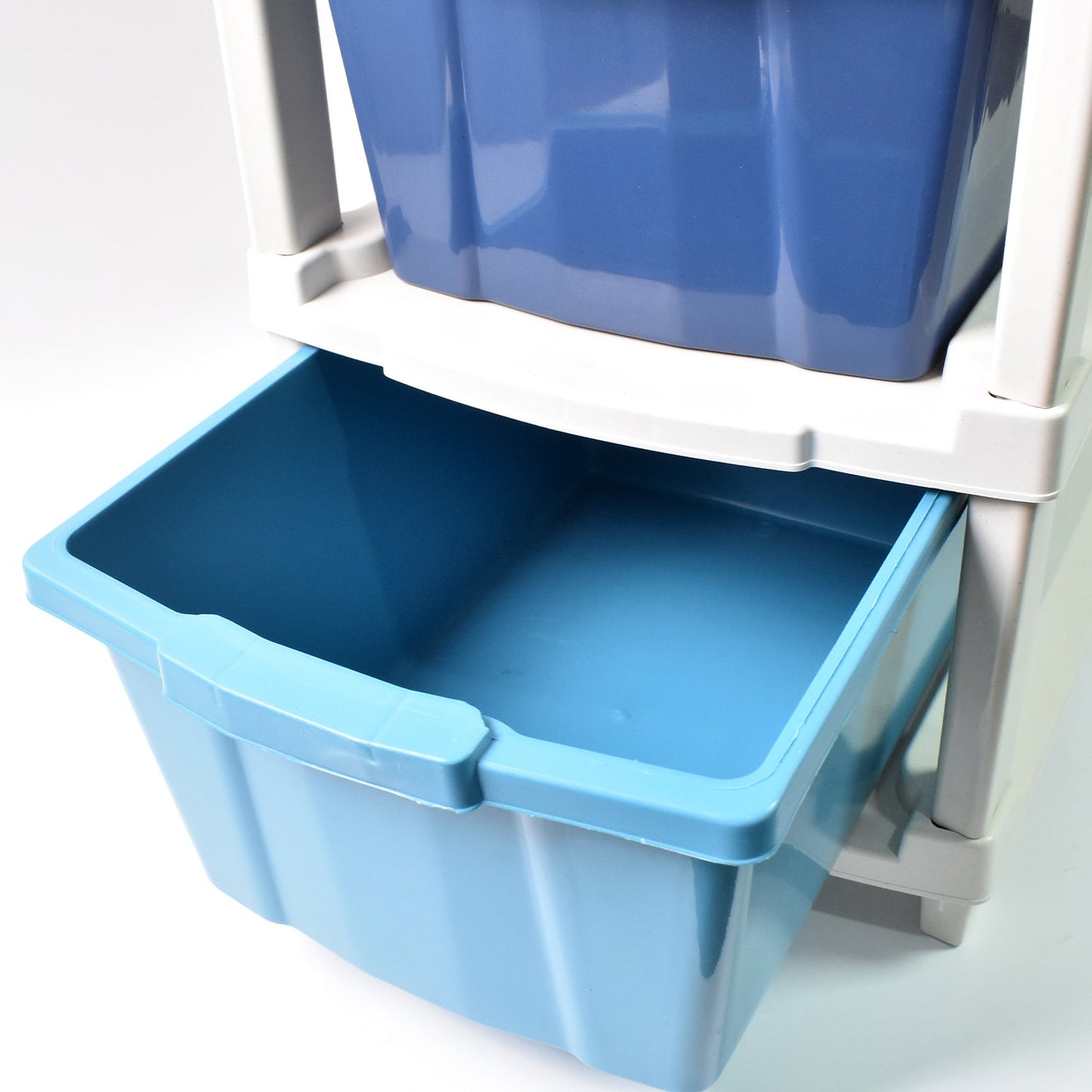 Close-up view of the transparent drawers of the 4-layer plastic storage unit, showing contents.
