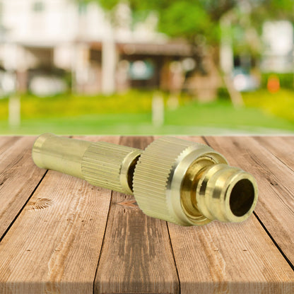 The brass water spray gun securely attached to a garden hose, ready for action.