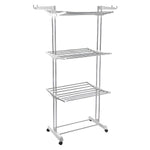 The 3-tier stainless steel drying rack with wheels, fully loaded with laundry.