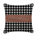A set of contemporary leather pillow covers arranged on a comfortable armchair.