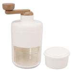 Ergonomic hand-cranked ice shaver with clear body, ready for home use.