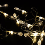 Decorative LED string lights draped over a curtain in a living room.