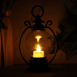 Decorative LED storm lantern displaying flickering flame effect on table