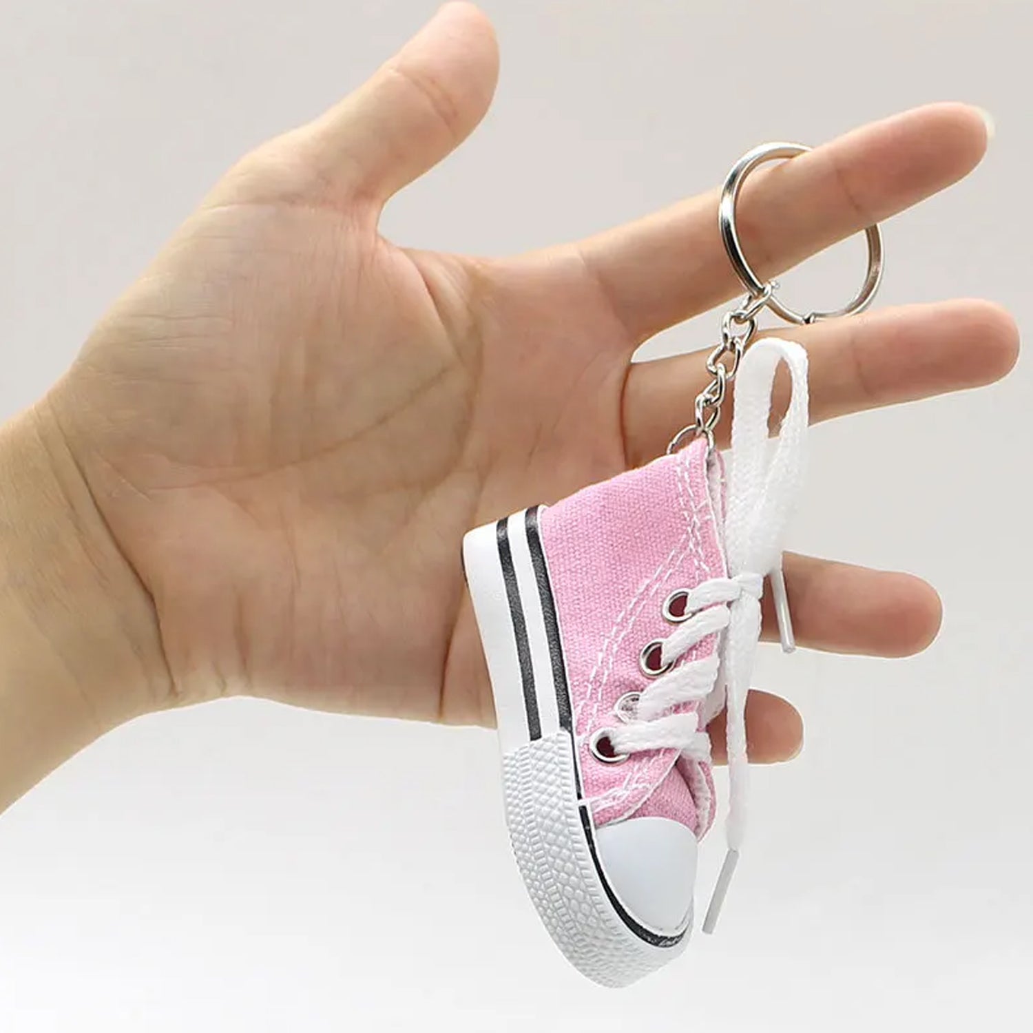 Detailed side view of a black mini shoe keychain with a metal ring.