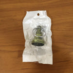 Metal temple bell keychain resting on textured surface background