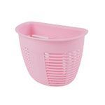Kitchen organizer basket mounted next to a sink, holding sponges and dishwashing liquid.