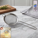 Close-up of stainless steel tea strainer with ergonomic long handle