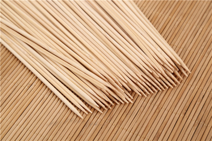 Close-up of raw meat and vegetables prepared on natural bamboo skewers.