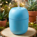 The compact USB Air Humidifier placed on a desk next to a laptop, highlighting its office suitability.