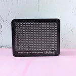 Close-up of money saving challenge board grid and black gel pen