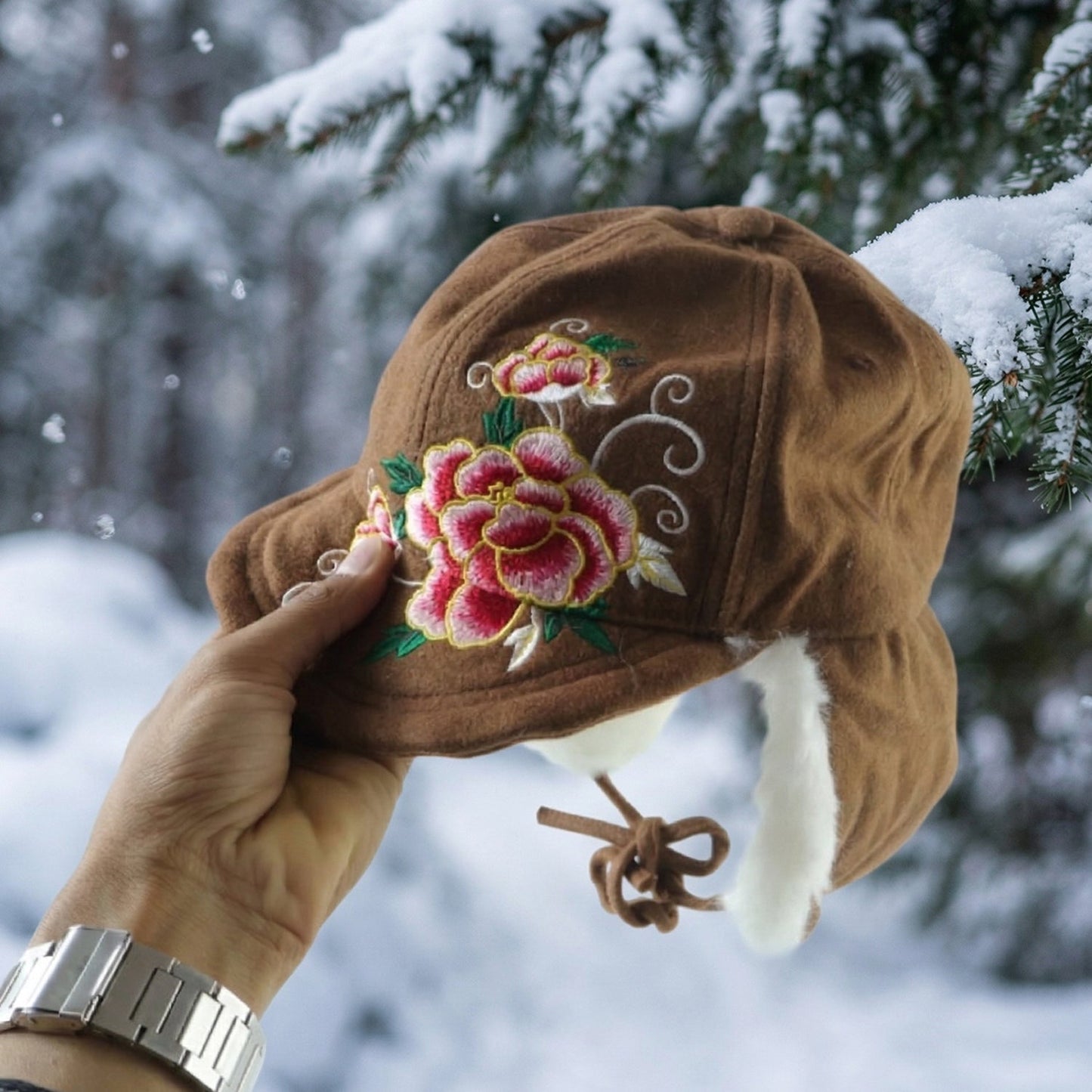 Stylish women’s winter cap featuring extended ear flaps and decorative embroidery