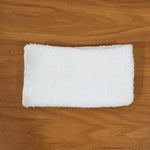 Person cleaning wooden furniture surface with microfiber cloth